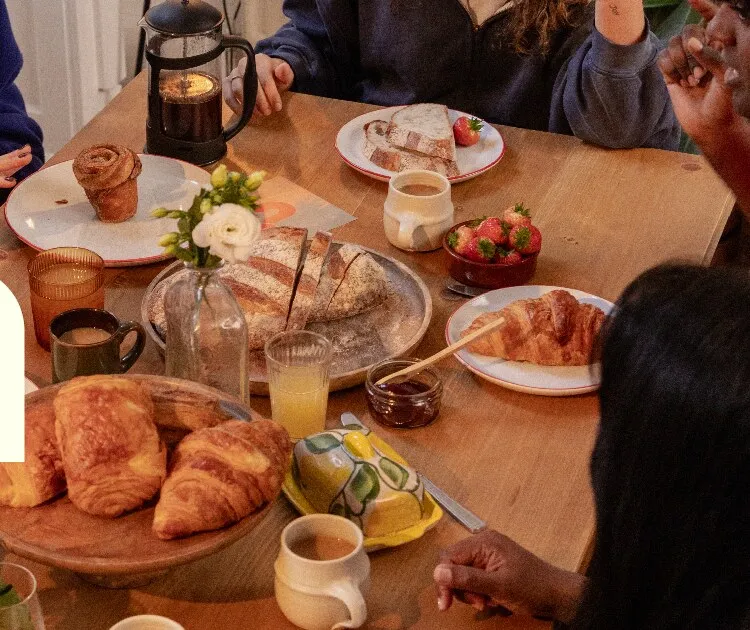 Friends laughing around a dinner table